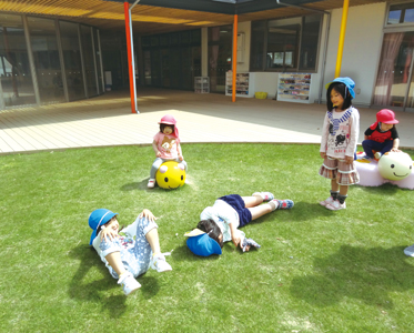 園庭の芝生で遊ぶ